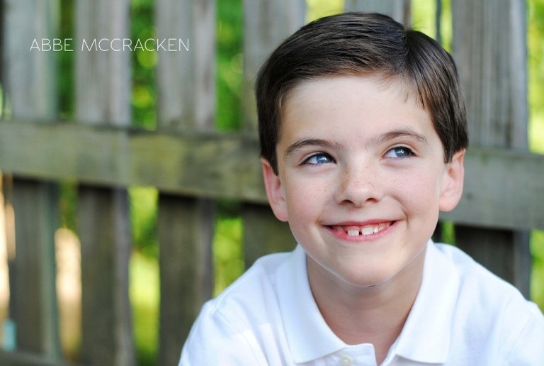 twin boy exchanging a knowing smile with twin sister (off camera)