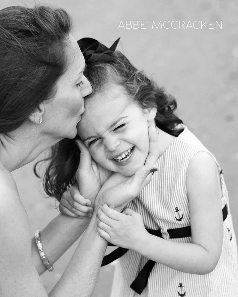 mother kissing daughter