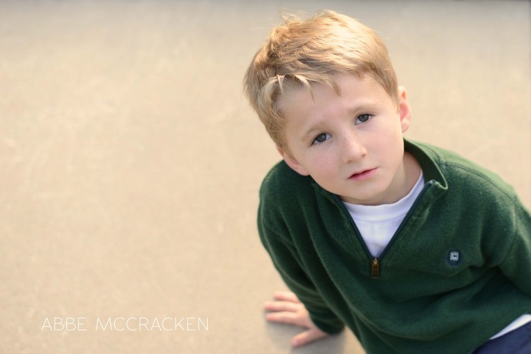 silly boy smirking on the sidewalk