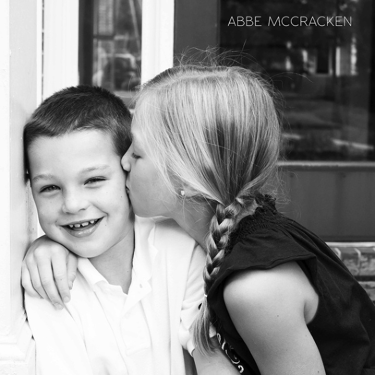 big sister kissing her little brother