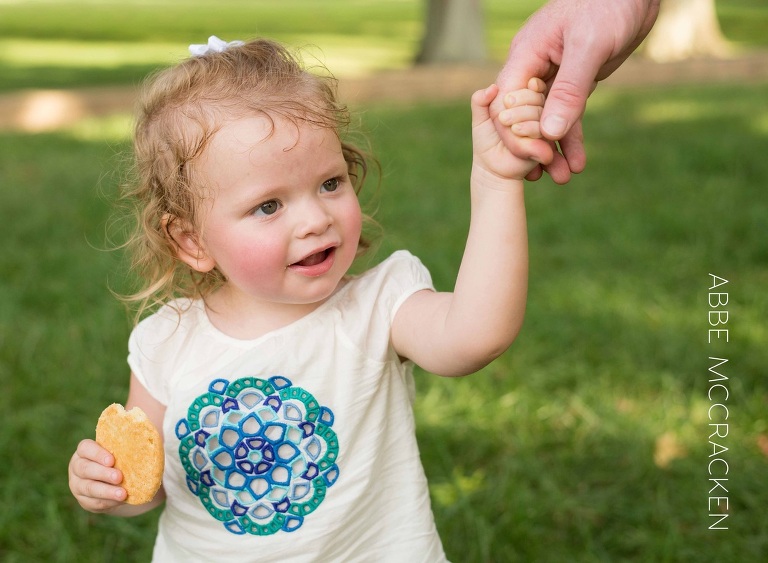 toddler grabbing her dad's hand