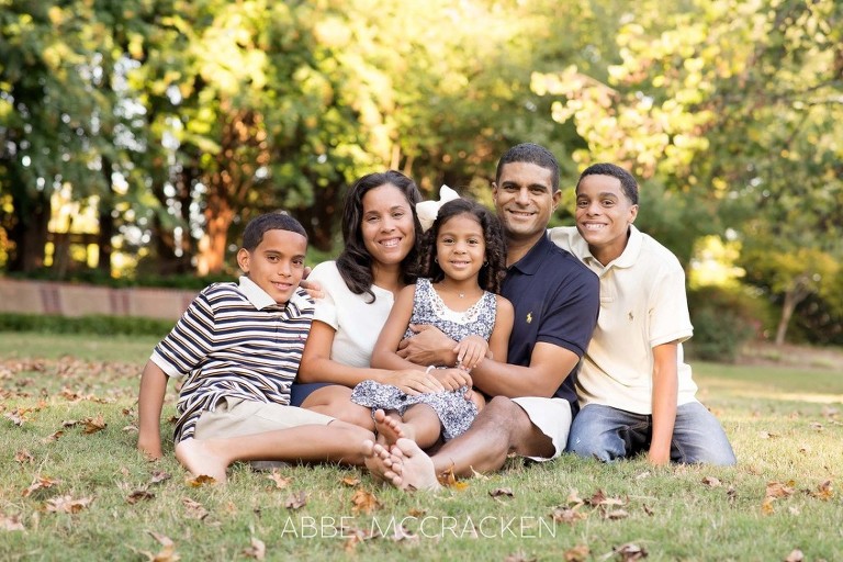 family sitting in the grass at Stumptown Park in Matthews