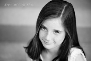 young girl with gorgeous bold freckles and a shy grin