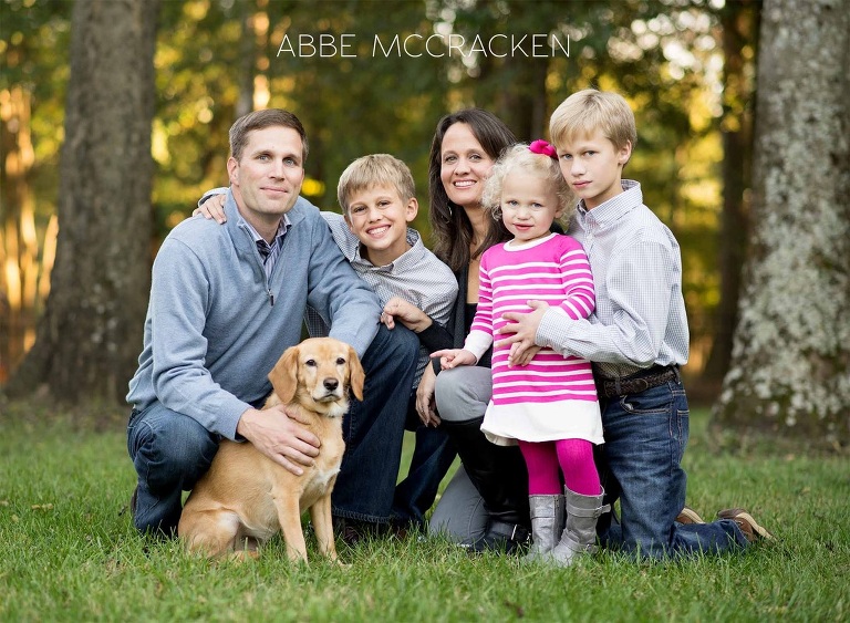 Family of five in their backyard with the dog