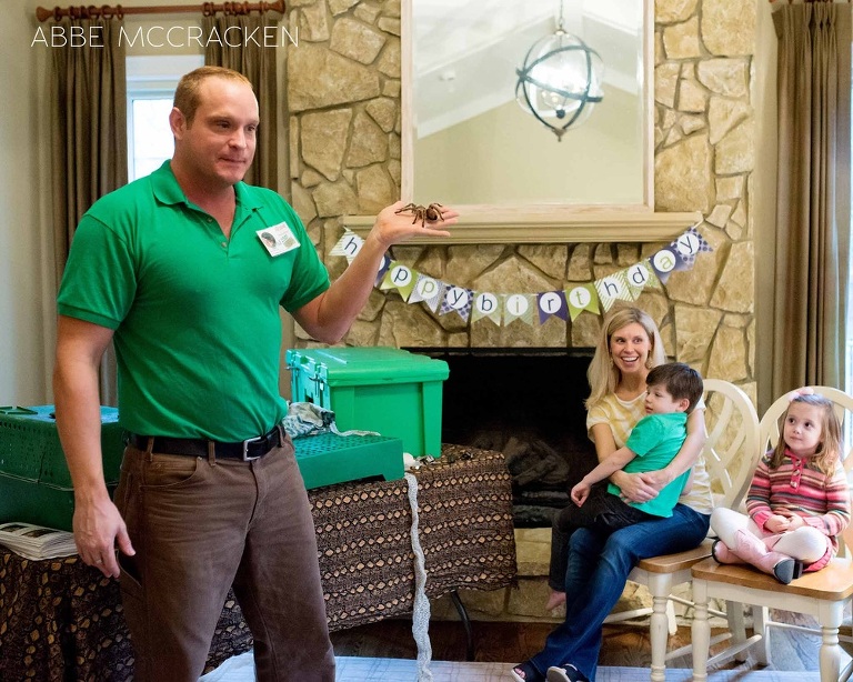 a staff member from Cold Blooded Encounters shows children a tarantula during a birthday party