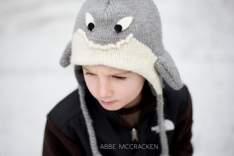 child wearing shark hat in snowy winter conditions