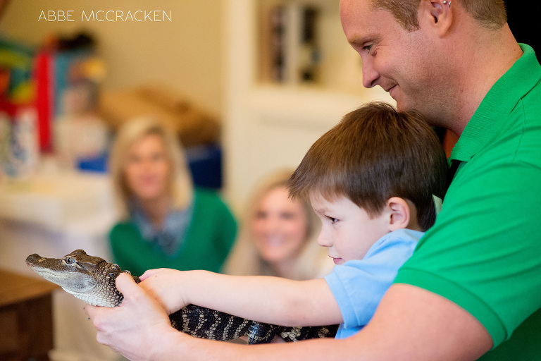 profile of birthday boy holding a baby alligator with the help of staff from Cold Blooded Encounters