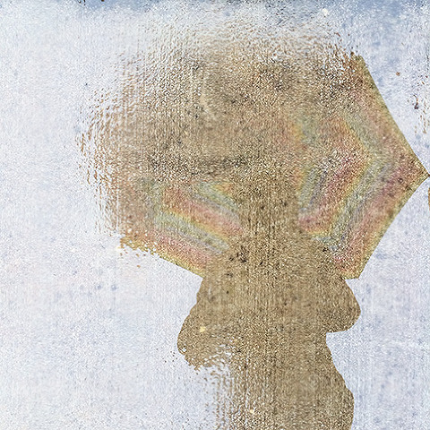 iPhone image - a reflection of photographer Abbe McCracken standing on a sidewalk in the rain