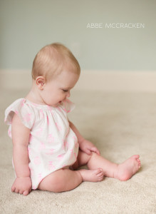 adorable baby girl sitting tall at 8 months old