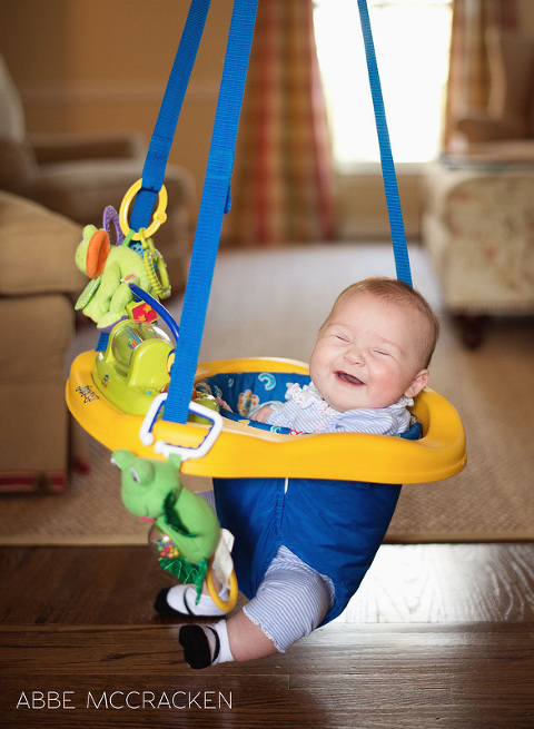 happy baby girl at home in swing, 4 months old