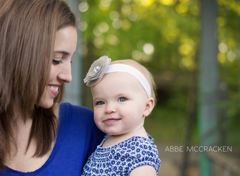 a young mother admiring her one year old baby girl