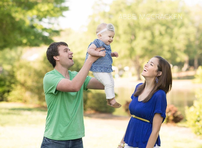 young parents playing in Freedom Park with their one year old baby