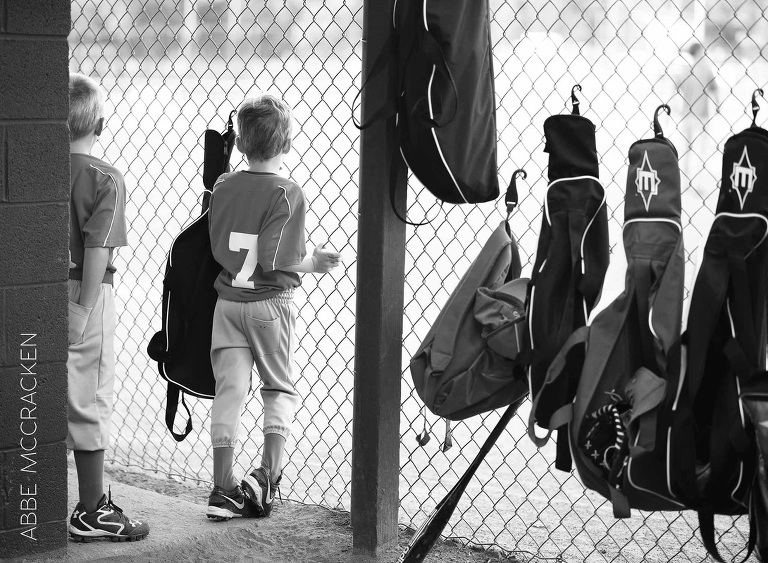 baseball players watch from the dugout, youth sports