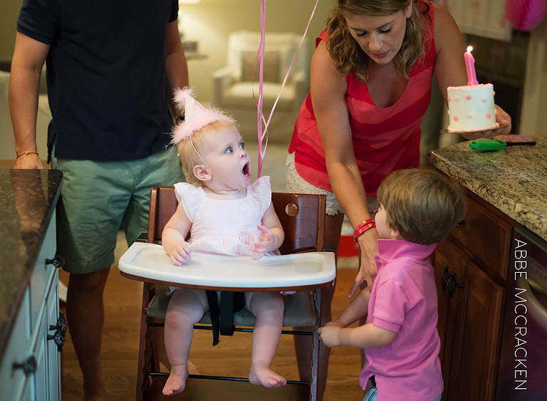 one year old girl sees her birthday cake for the first time