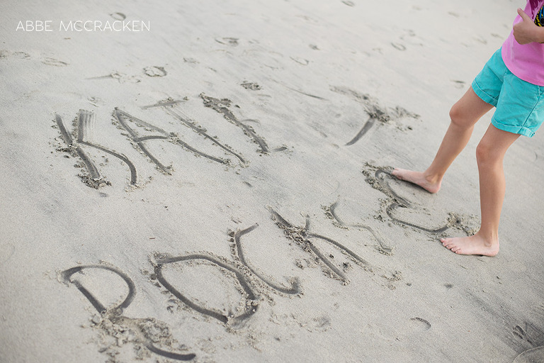 Child writing in the sand - beach photography