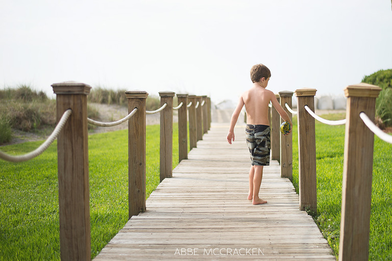 young boy beach bound on the boardwalk