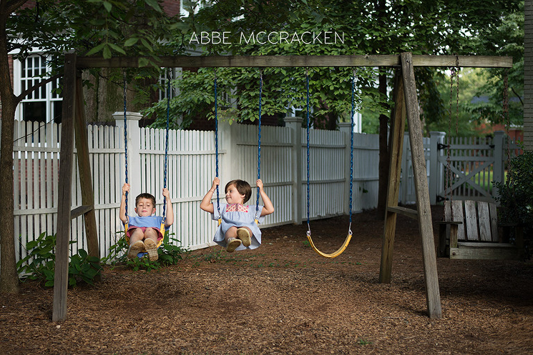 children swinging in their own backyard