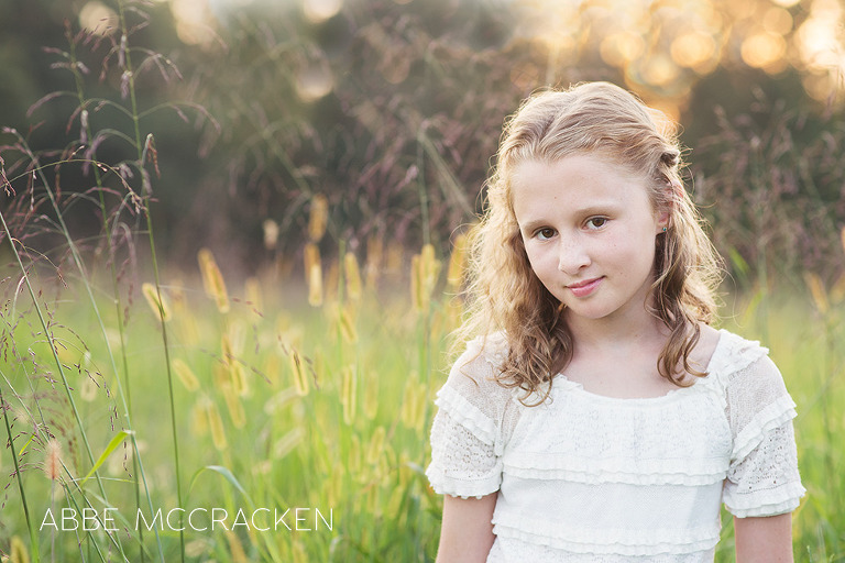 young girl posing in a field of tall grasses