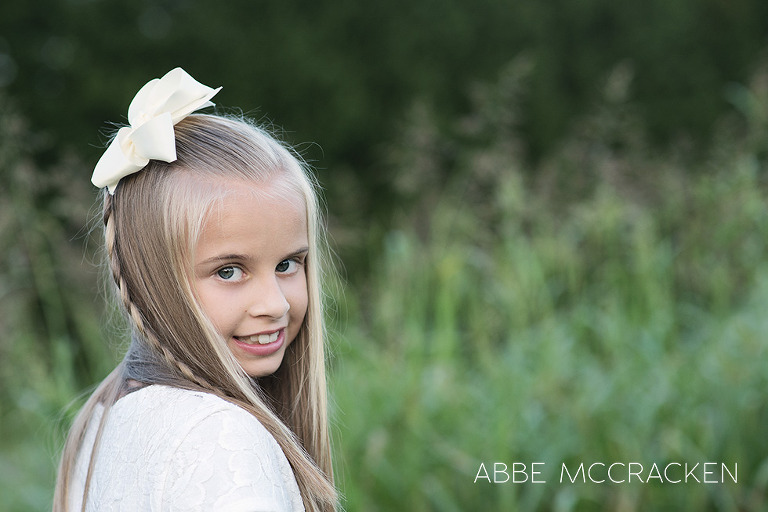 childrens headshot in a luscious green field