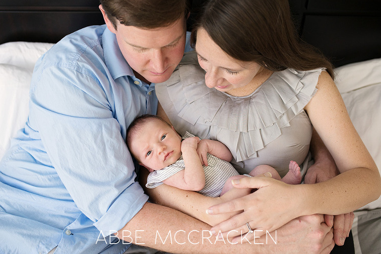 Natural light newborn lifestyle session, baby snuggled in parent's arms