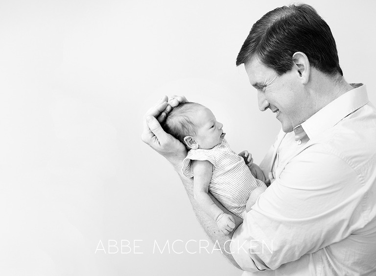 newborn girl sticking her tongue out at dad