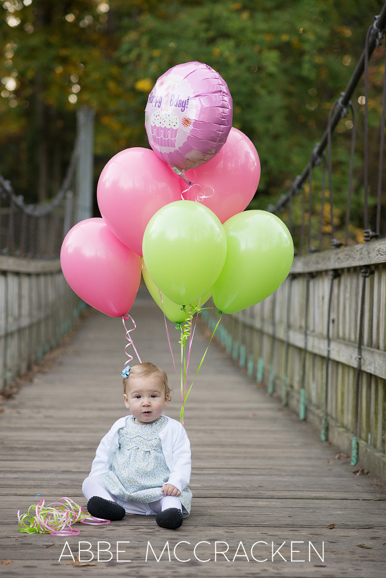 One year old birthday girl with colorful balloons