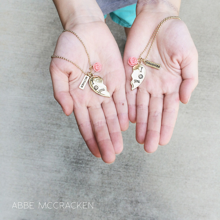 child holding out mother daughter necklace for her mom, iphoneography