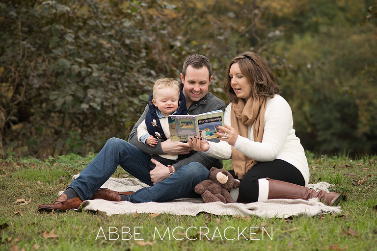parents reading to baby boy in the park