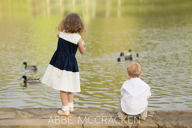 lifestyle photography of siblings feeding ducks in Charlotte NC