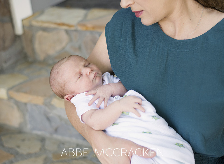 newborn baby boy asleep in mother's arms