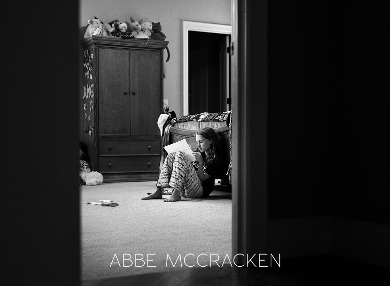 Black and white portrait of a tween girl studying in her room