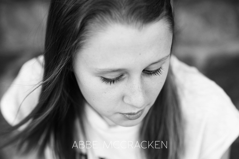 Black and white portrait of a tween girl, focus on the dark eyelashes and gorgeous hair blowing in the wind