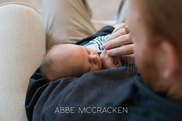Newborn baby boy sleeping in daddy's arms