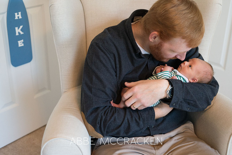 Newborn baby boy looking wide-eyed at his father