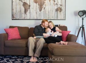 Candid Image Of A Family Of Four Snuggling On The Couch Taken