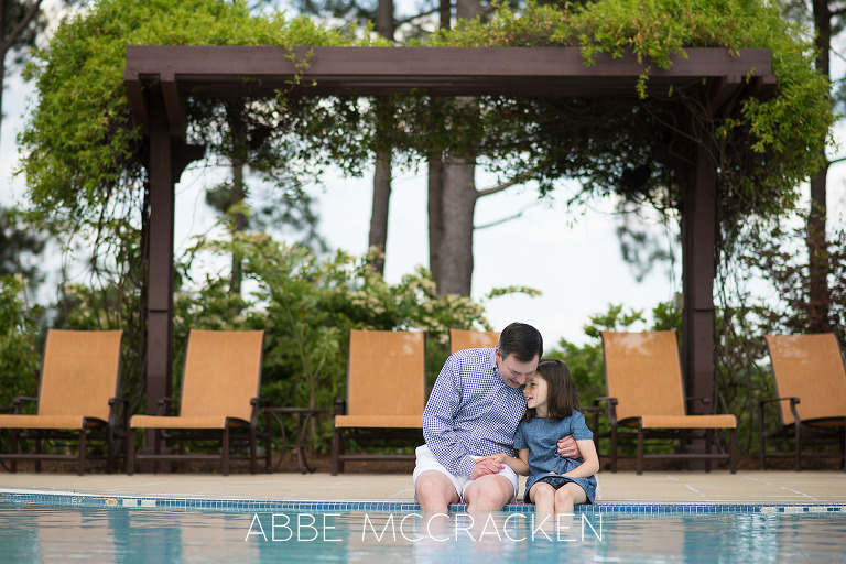 Lifestyle photography of a father and daughter dipping their feet in the pool at Carmel County Club