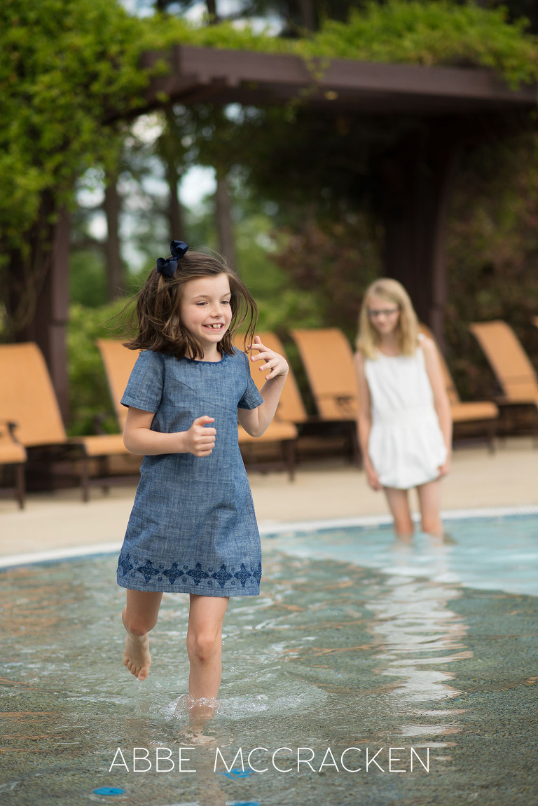 Family photography - candid image of young girl running in the Carmel Country pool