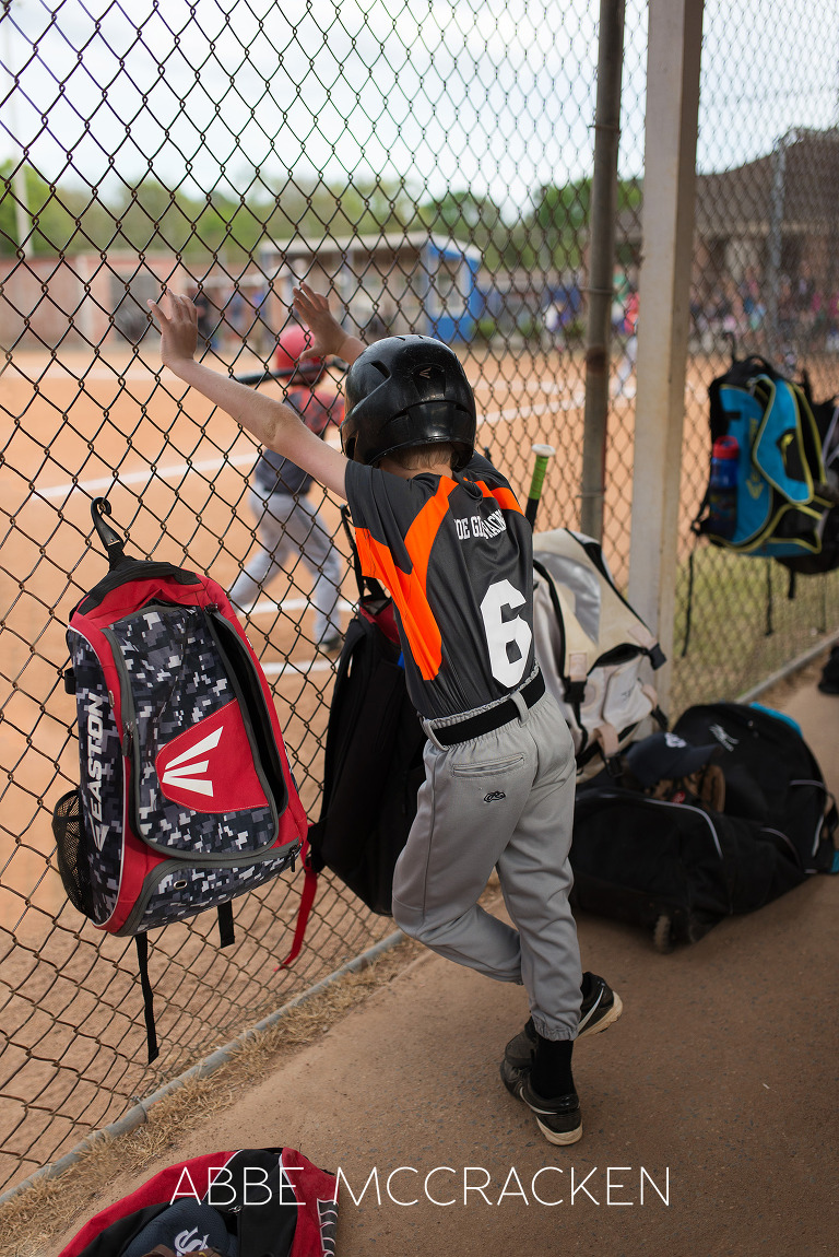 Youth baseball at South Charlotte Recreation Association, image of a young boy waiting in the dugout