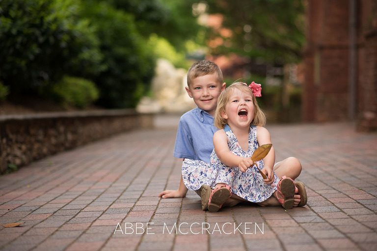Siblings laughing at each other during a family photography session in Uptown Charlotte