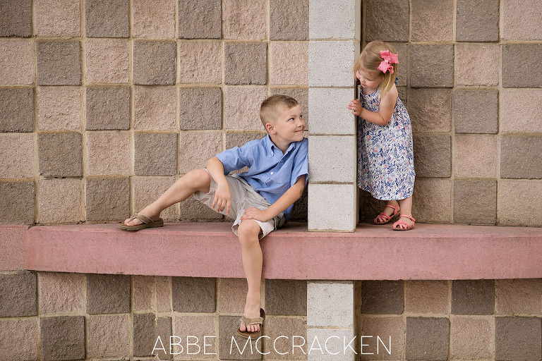 Candid photograph of siblings playing on a funky wall in Uptown Charlotte