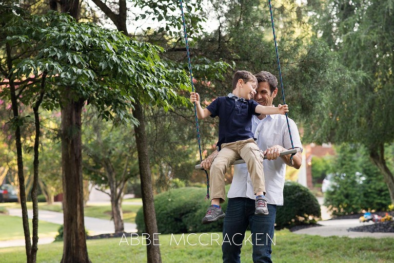 Summer family photo session - Father swinging his son in their Charlotte, NC front yard