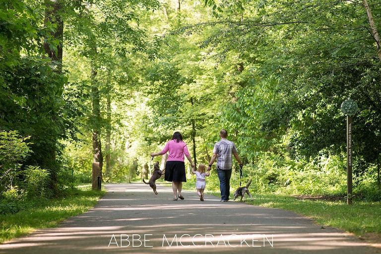 Family of five - 3 humans, 2 dogs - walking on a paved trail in Charlotte NC's Freedom Park