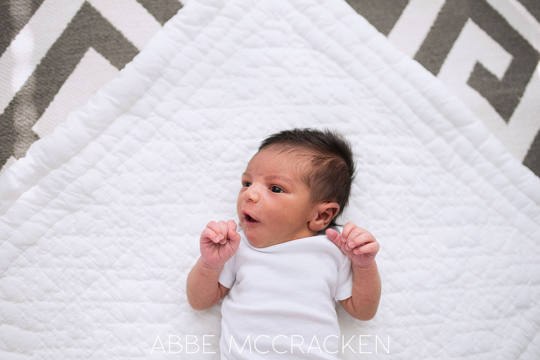 Newborn baby boy laying on the floor during his at home photography session