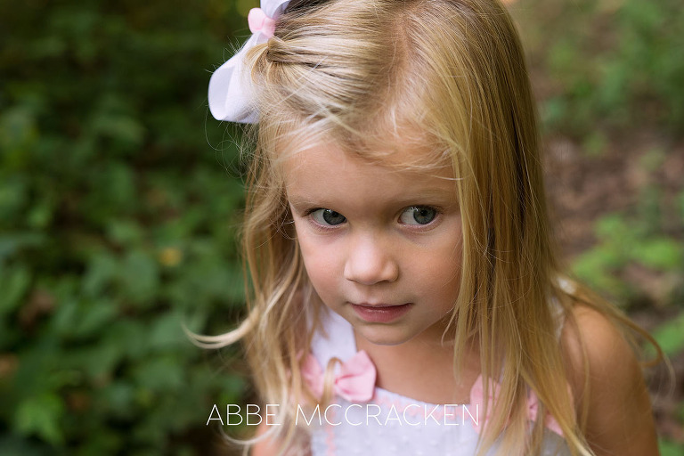 Portrait of a three year old, blonde girl with white box in her hair
