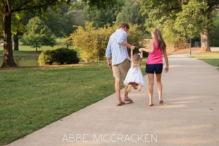 Family of three playing in Charlotte's Freedom Park