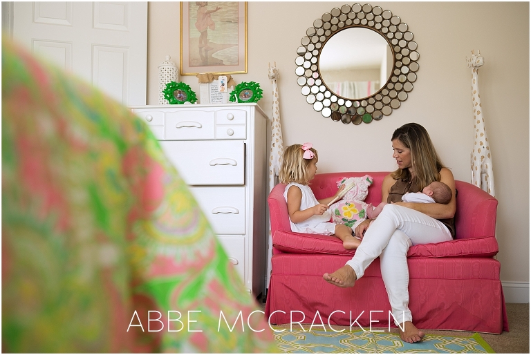 Newborn lifestyle photography session - mom, baby and big sister reading in big sister's room