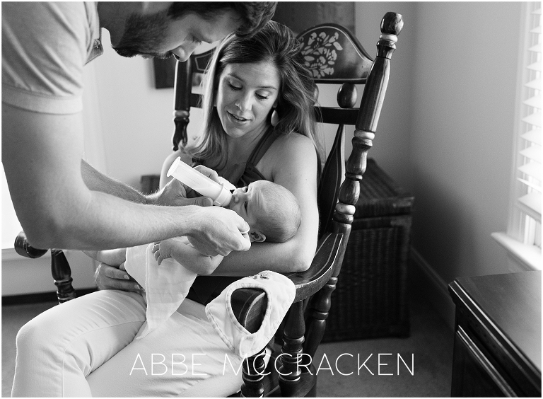 Newborn lifestyle photography session - portrait of parents feeding baby boy