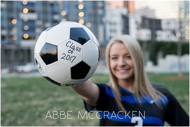 Senior portraits in Uptown Charlotte - girl in high school soccer jersey