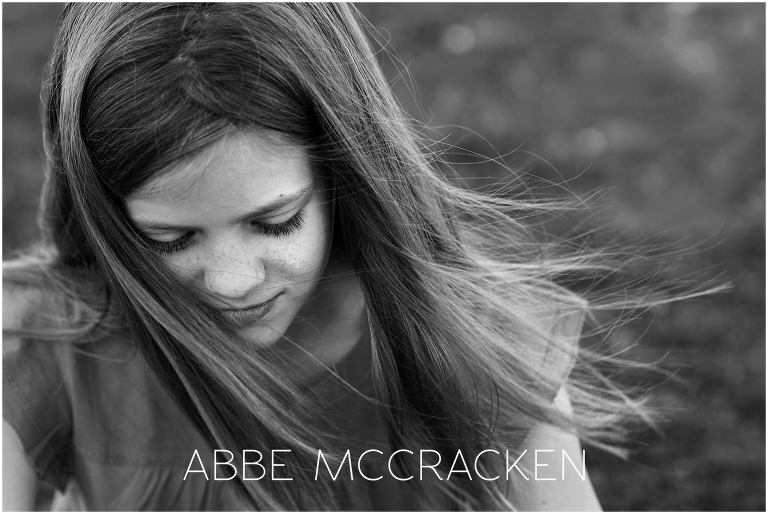 Black and white portrait of a young girl with long hair blowing in the wind