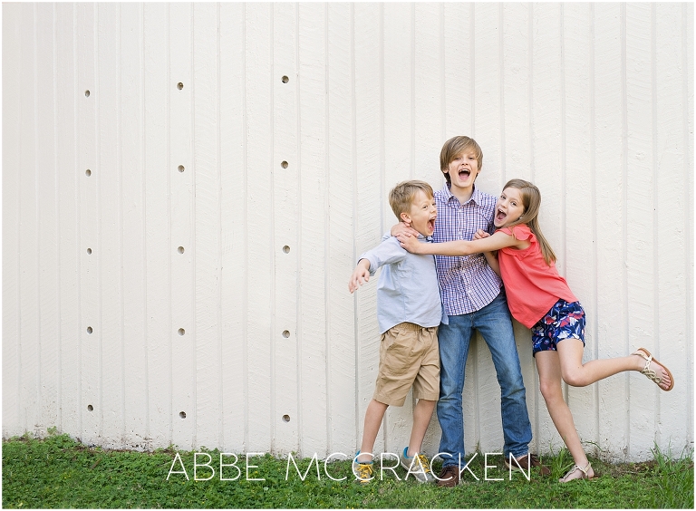 Candid picture of three joyful siblings taken during a family photography session